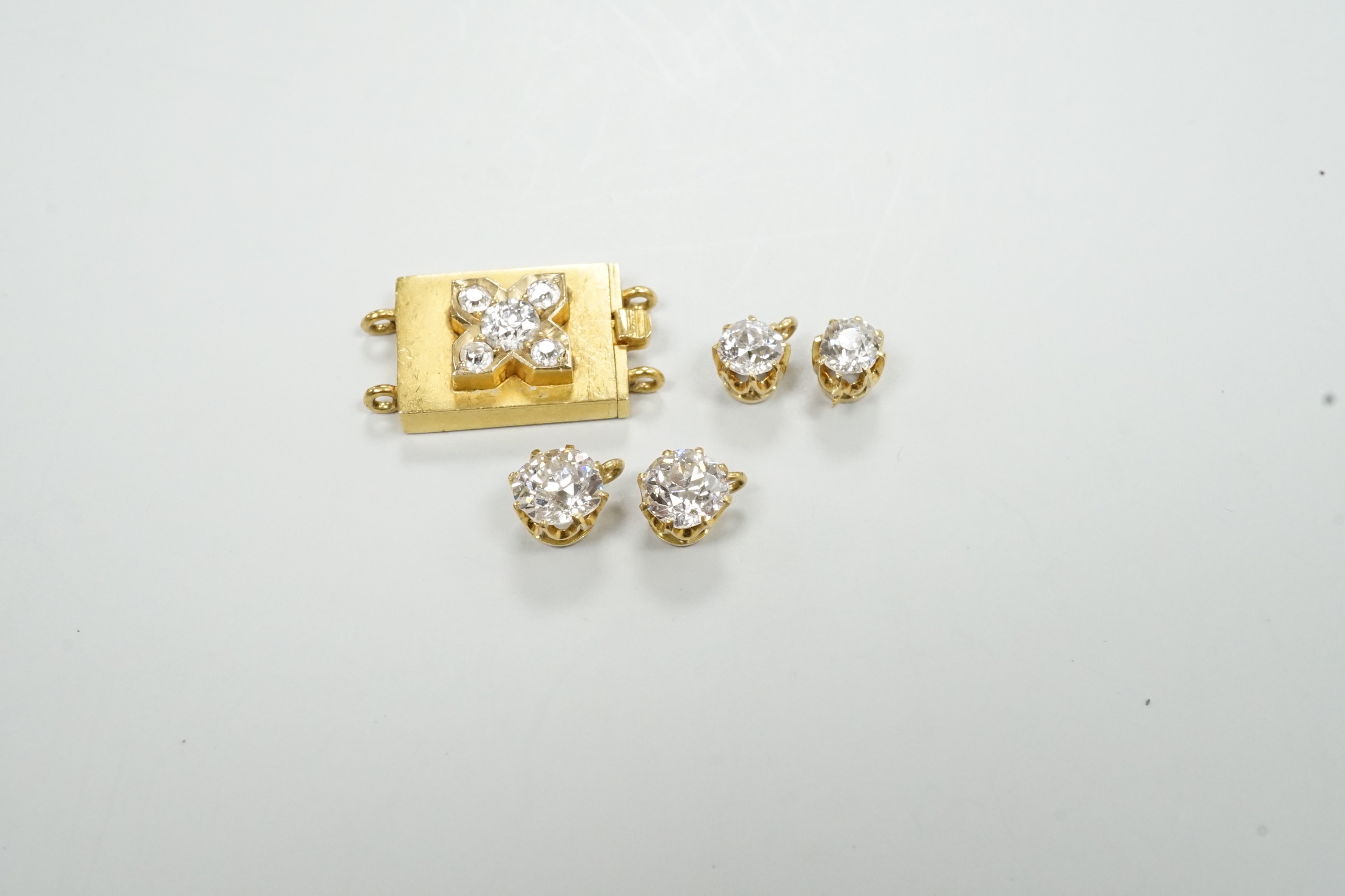 Four yellow metal and diamond set pendants and a diamond set yellow metal clasp.
